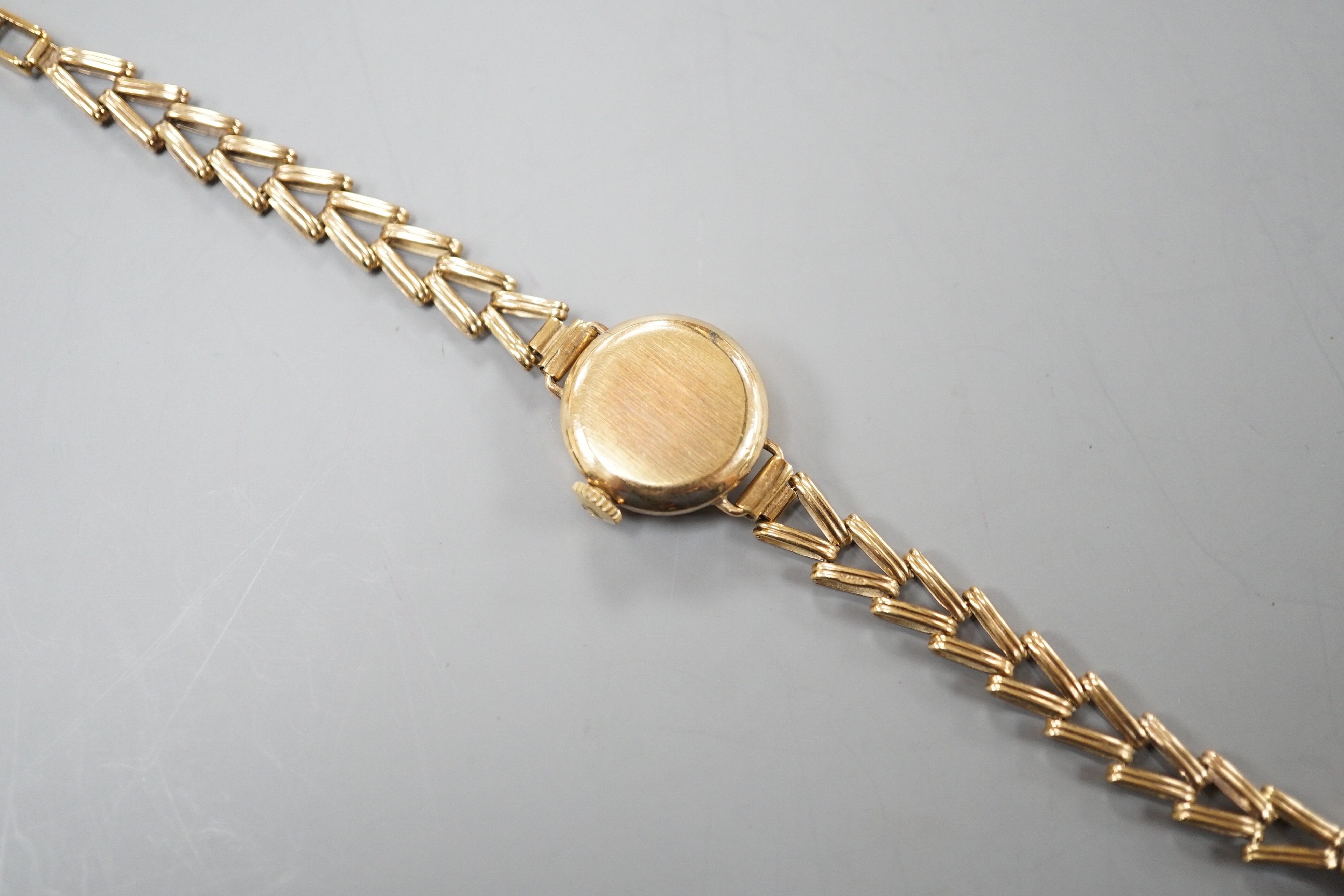 A lady's 9ct gold Tissot manual wind wrist watch, on a 9ct gold bracelet, overall length 16.25cm, gross weight 11.2 grams.